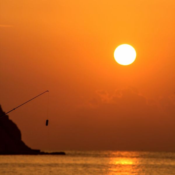 Person stretching outdoors during a beautiful sunset.